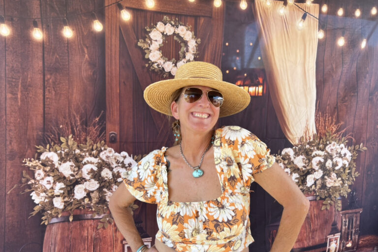 A woman in a straw hat and sunglasses.