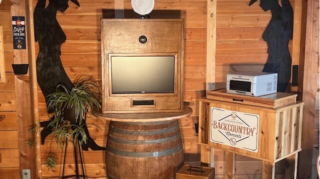 A wooden barrel with a television on top of it.