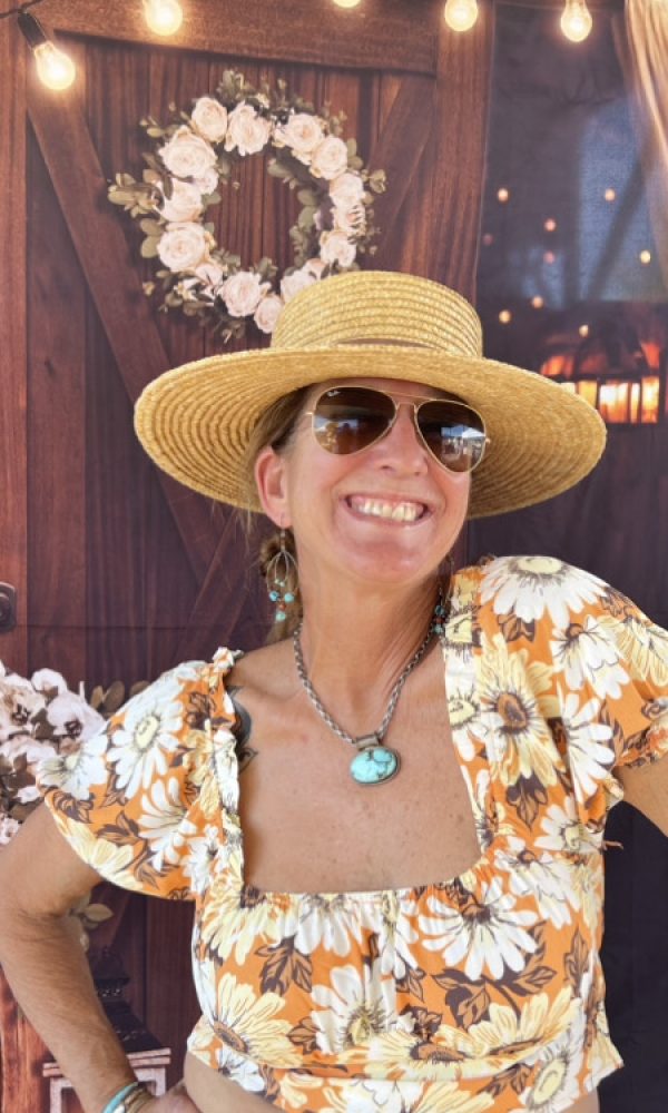 A woman in a straw hat and sunglasses.